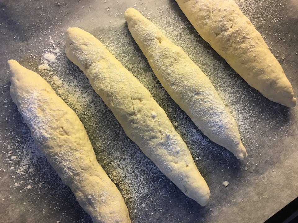 Bak ut 4 baguetter som du legger på bakepapir. Bruk en kniv til å snitte og strø over mel